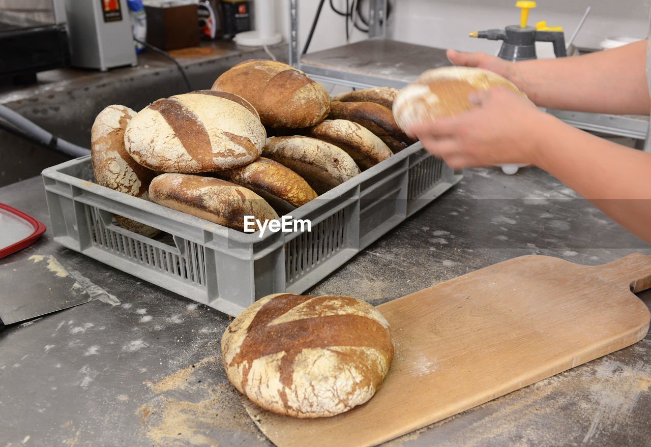 Close-up of hand holding bread at counter in kitchen