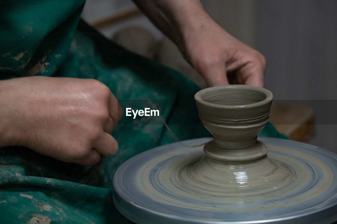 potter's wheel, art, pottery, craft, hand, skill, occupation, spinning, clay, wheel, ceramic, craftsperson, working, expertise, molding a shape, creativity, making, workshop, earthenware, one person, motion, adult, shape, men, craft product, holding, close-up, pitcher - jug, mud