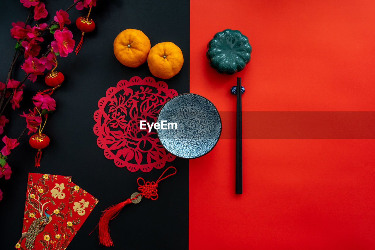 Chinese lunar new year decoration over red and black background. flat lay dinning table concept.