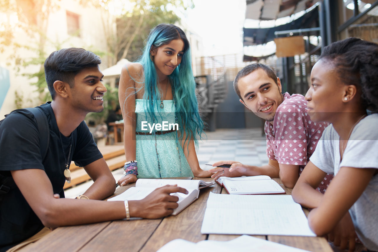 Cheerful friends studying at campus