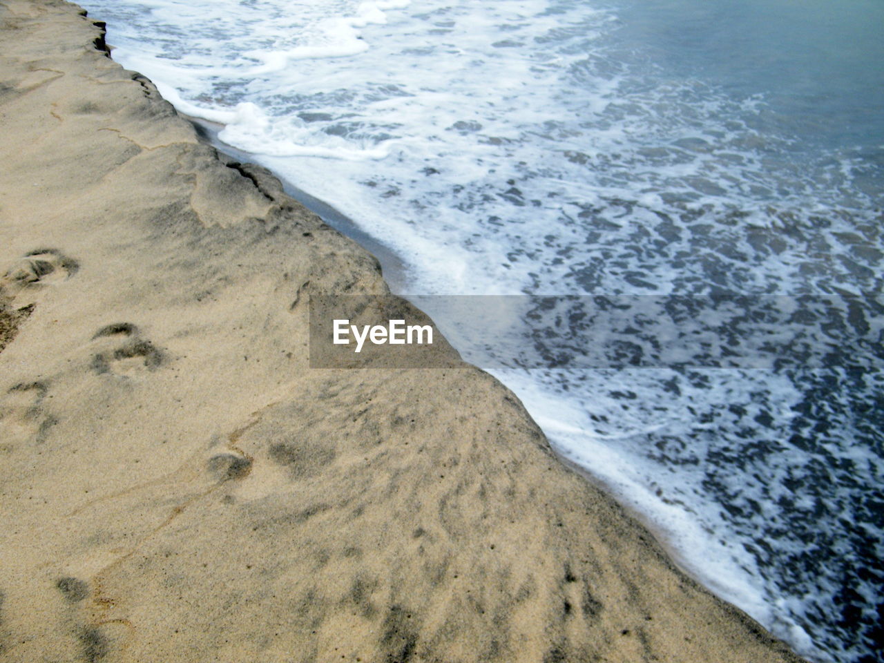 HIGH ANGLE VIEW OF WAVES REACHING SHORE