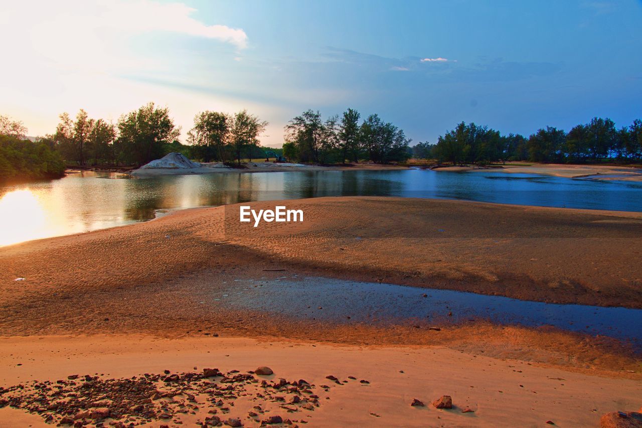 SCENIC VIEW OF BEACH AGAINST SKY AT SUNSET