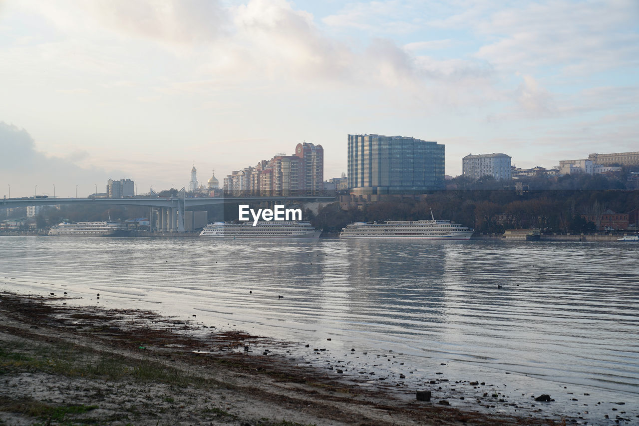 RIVER BY BUILDINGS AGAINST SKY IN CITY