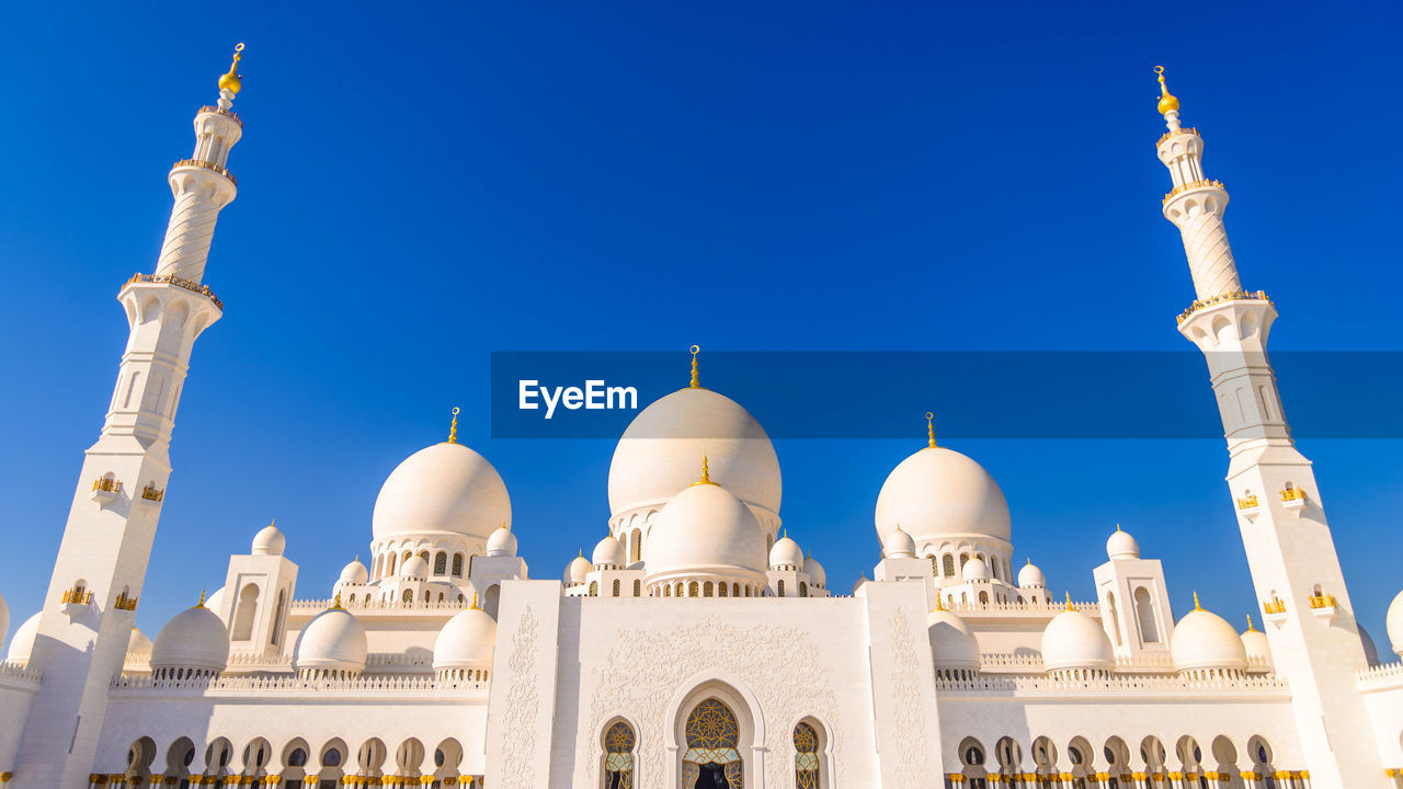 Low angle view of sheikh zayed mosque against clear blue sky