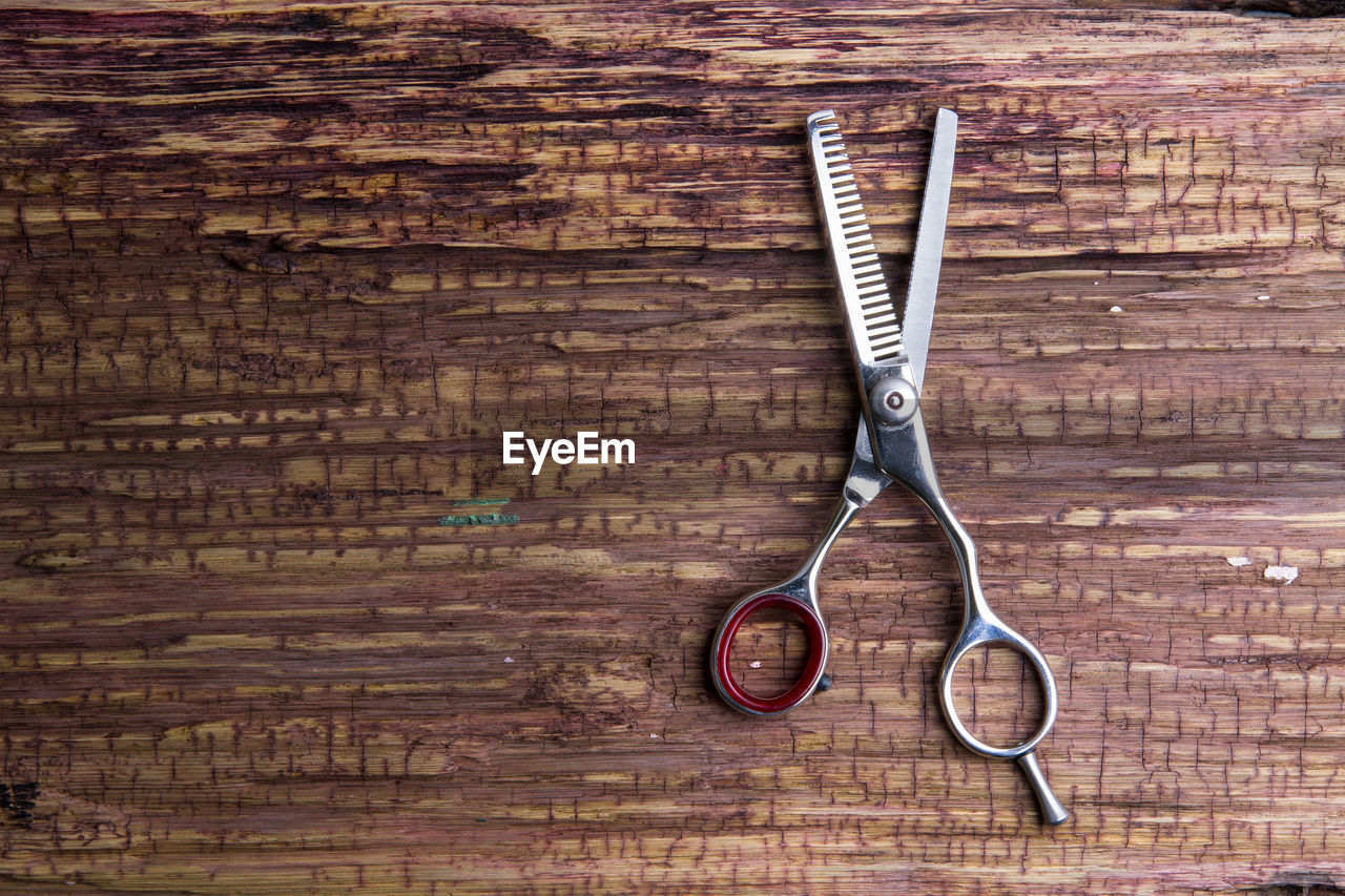 Close-up of scissor on wooden table