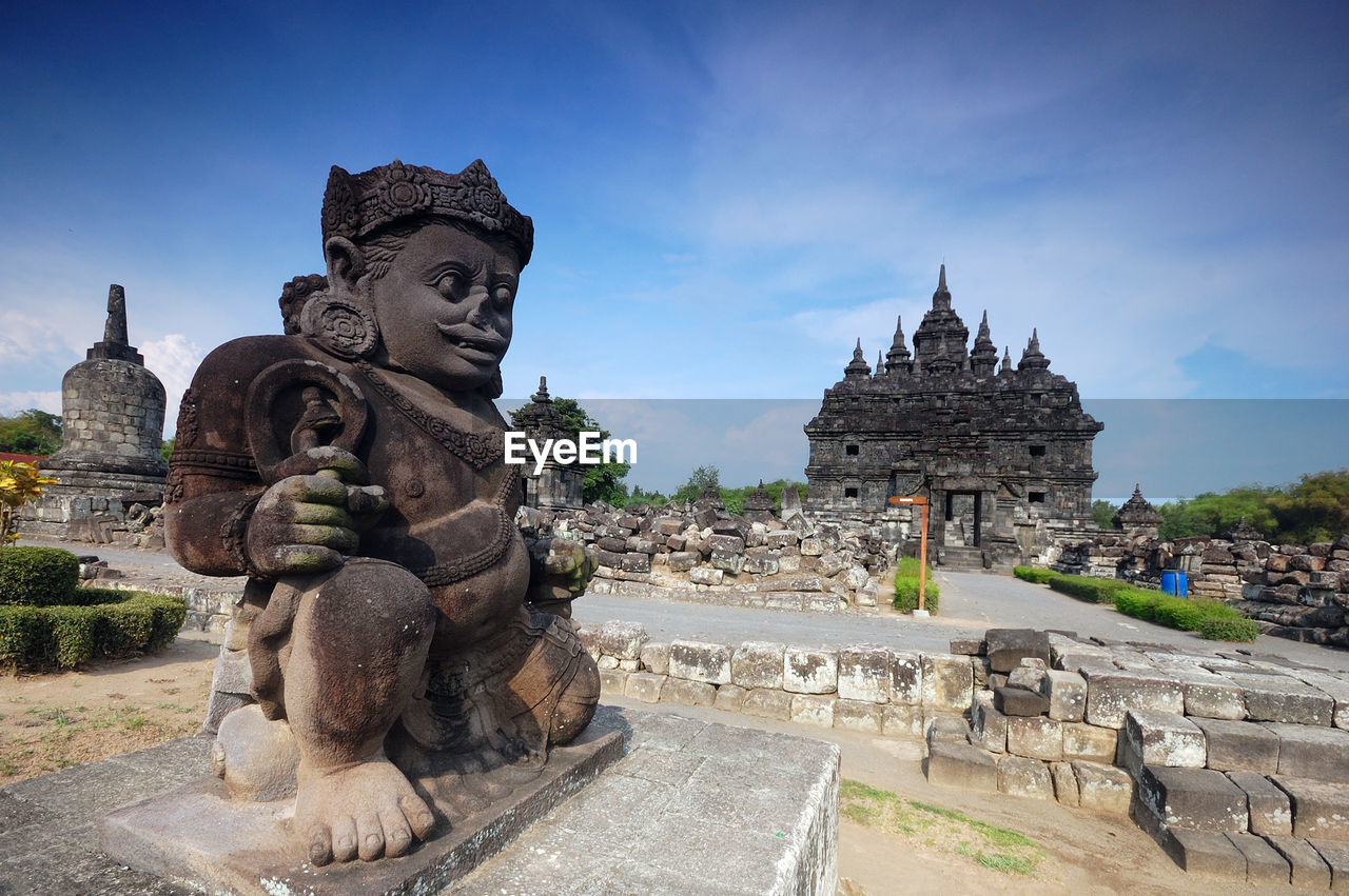 Statue at old ruin temple against sky