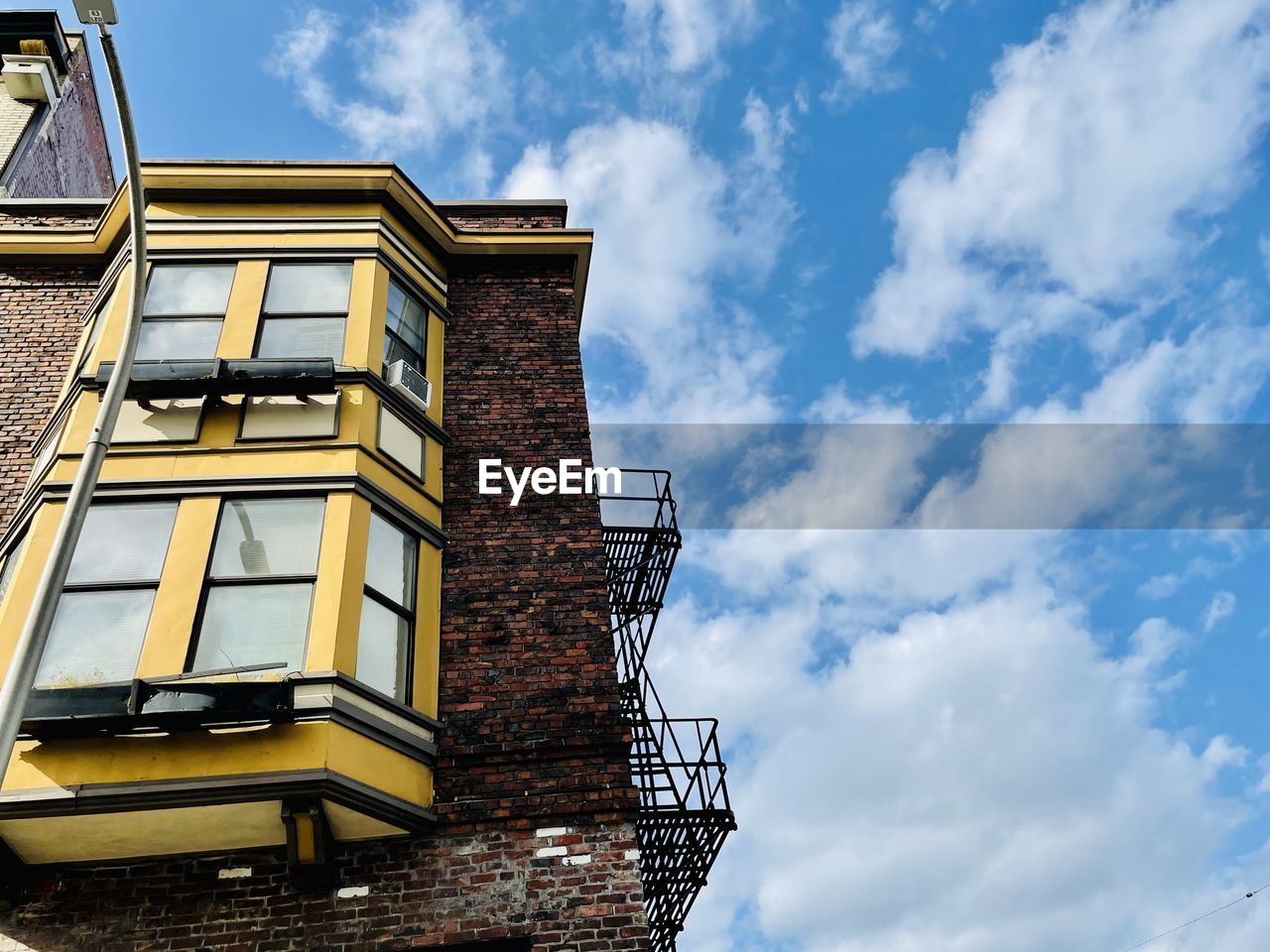 LOW ANGLE VIEW OF YELLOW BUILDINGS AGAINST SKY