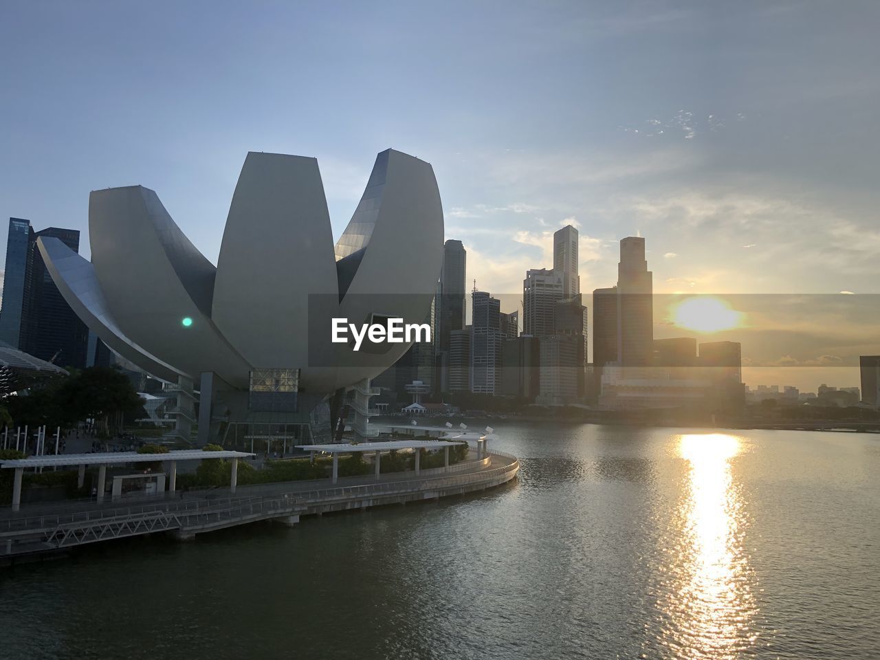 MODERN BUILDINGS BY RIVER AGAINST SKY IN CITY