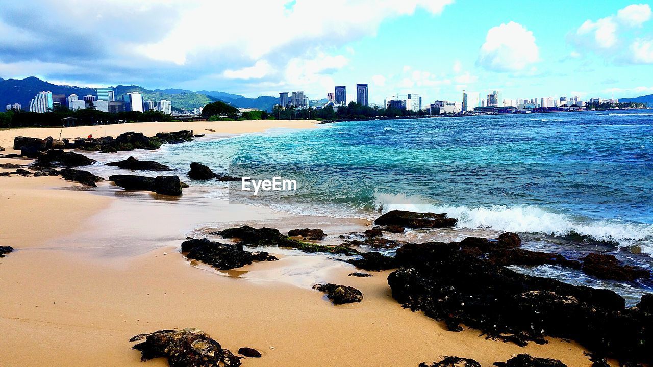 VIEW OF BEACH AGAINST CLOUDY SKY