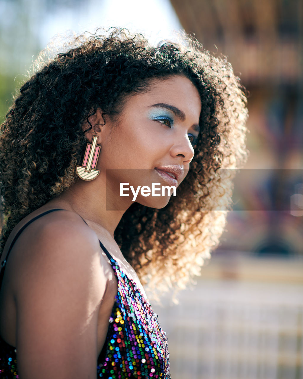 Fashionable young woman looking away in city