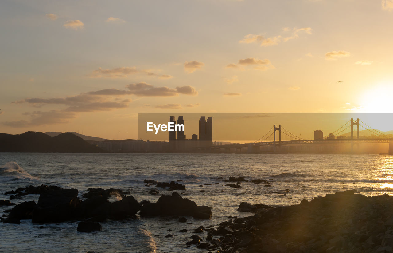 Scenic view of bay against sky during sunset