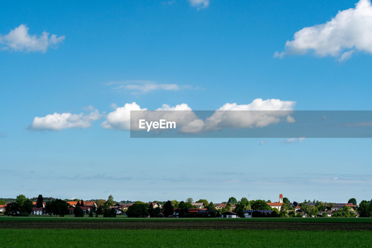 sky, horizon, cloud, field, grass, environment, nature, landscape, plant, plain, architecture, land, rural area, built structure, blue, agriculture, grassland, day, outdoors, beauty in nature, building exterior, building, rural scene, scenics - nature, tree, no people, farm, dusk, meadow, city, travel destinations, green, prairie