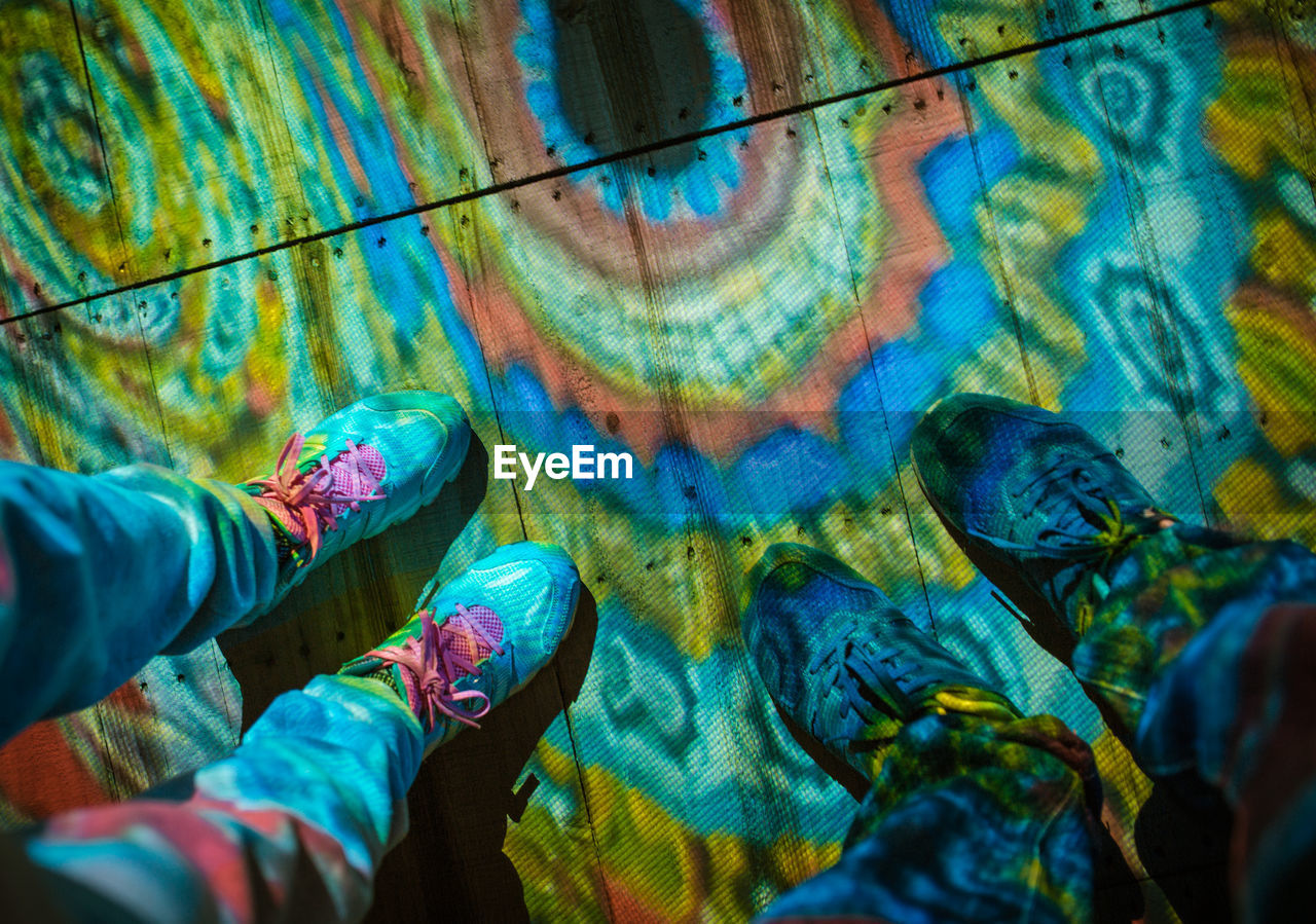 Low section of people standing on colorful floor