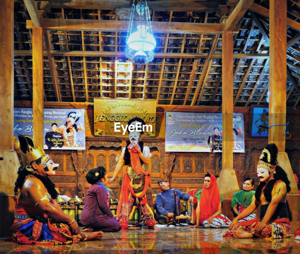 GROUP OF PEOPLE IN ILLUMINATED SHOP