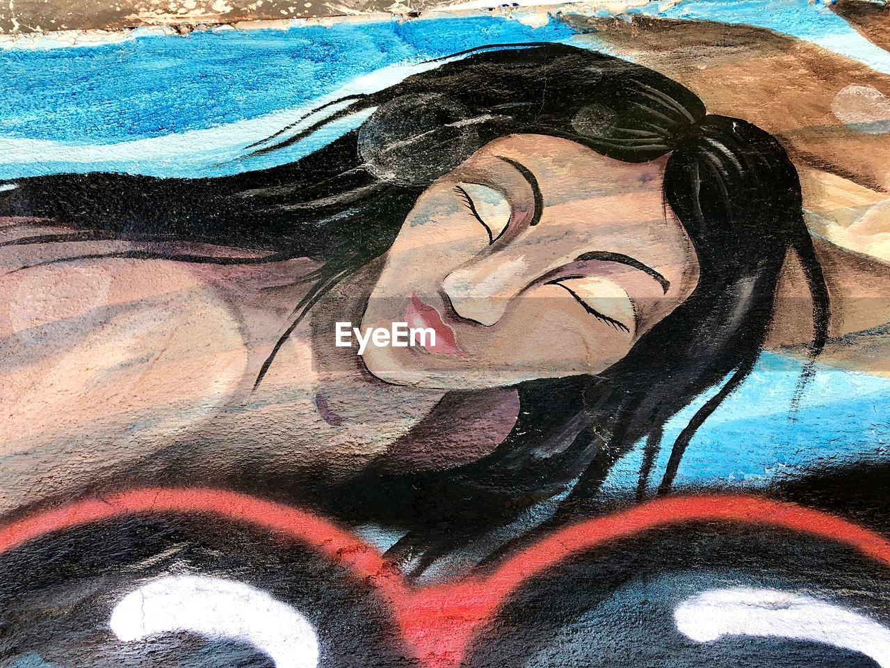 CLOSE-UP PORTRAIT OF YOUNG WOMAN AGAINST GRAFFITI WALL