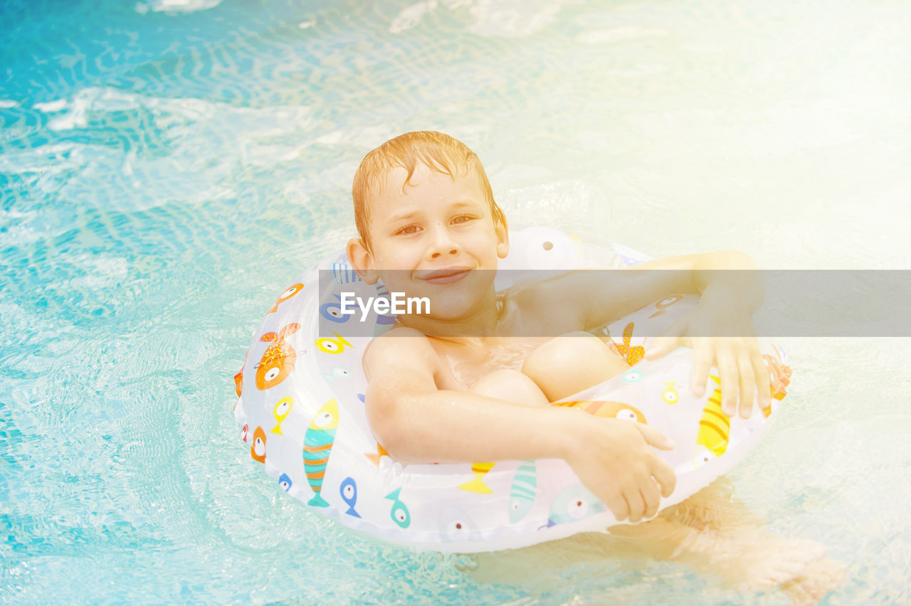High angle portrait of smiling boy in swimming pool
