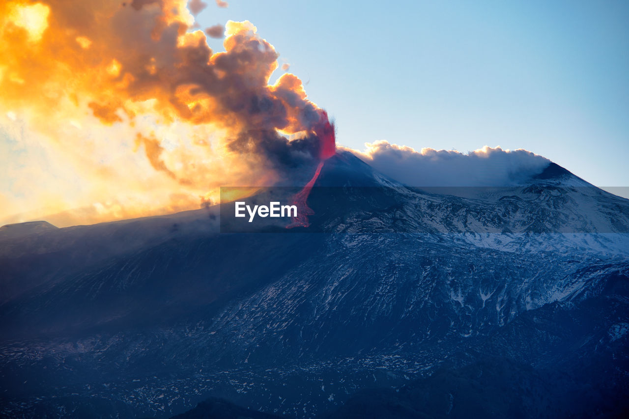 Scenic view of snowcapped volcano against sky during sunset