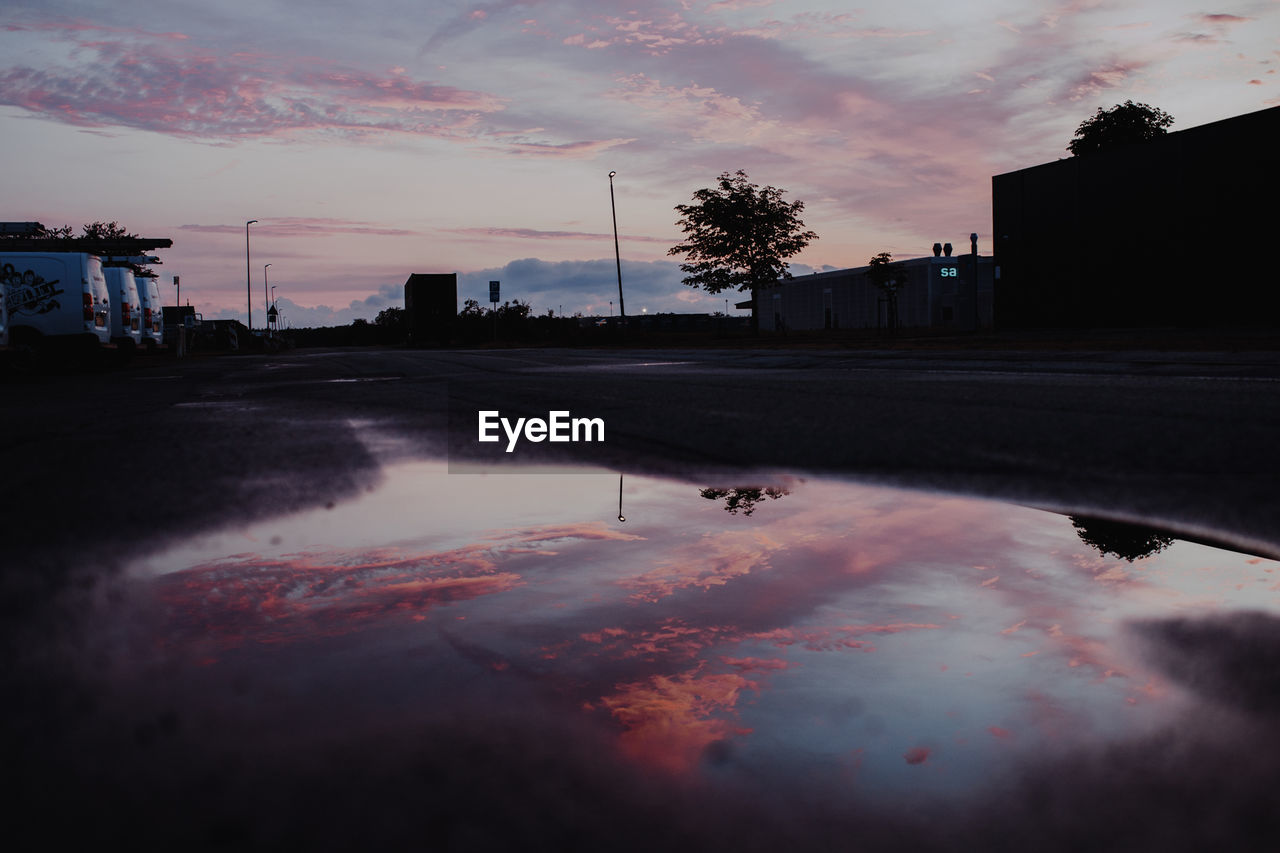 REFLECTION OF SKY IN PUDDLE ON ROAD