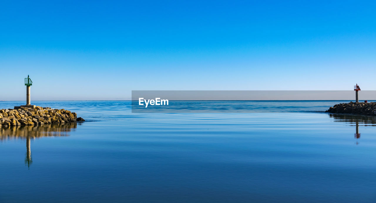 Scenic view of sea against clear blue sky during sunset