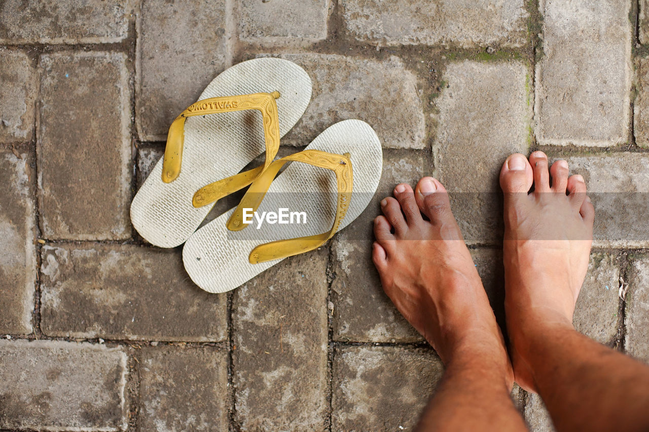 Low section of man standing on tiled floor