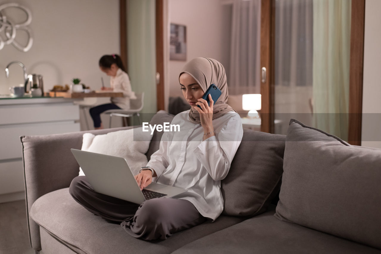 Muslim mother working at home