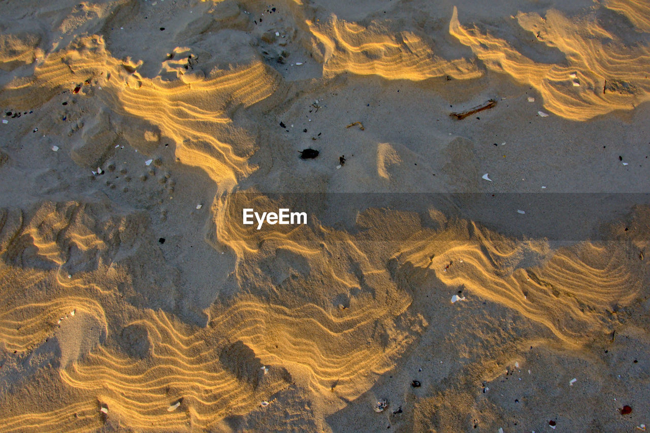 HIGH ANGLE VIEW OF WET SAND ON BEACH