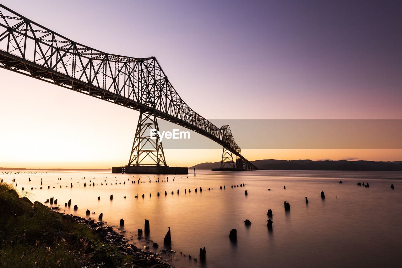 Low angle view of bridge over river against sky