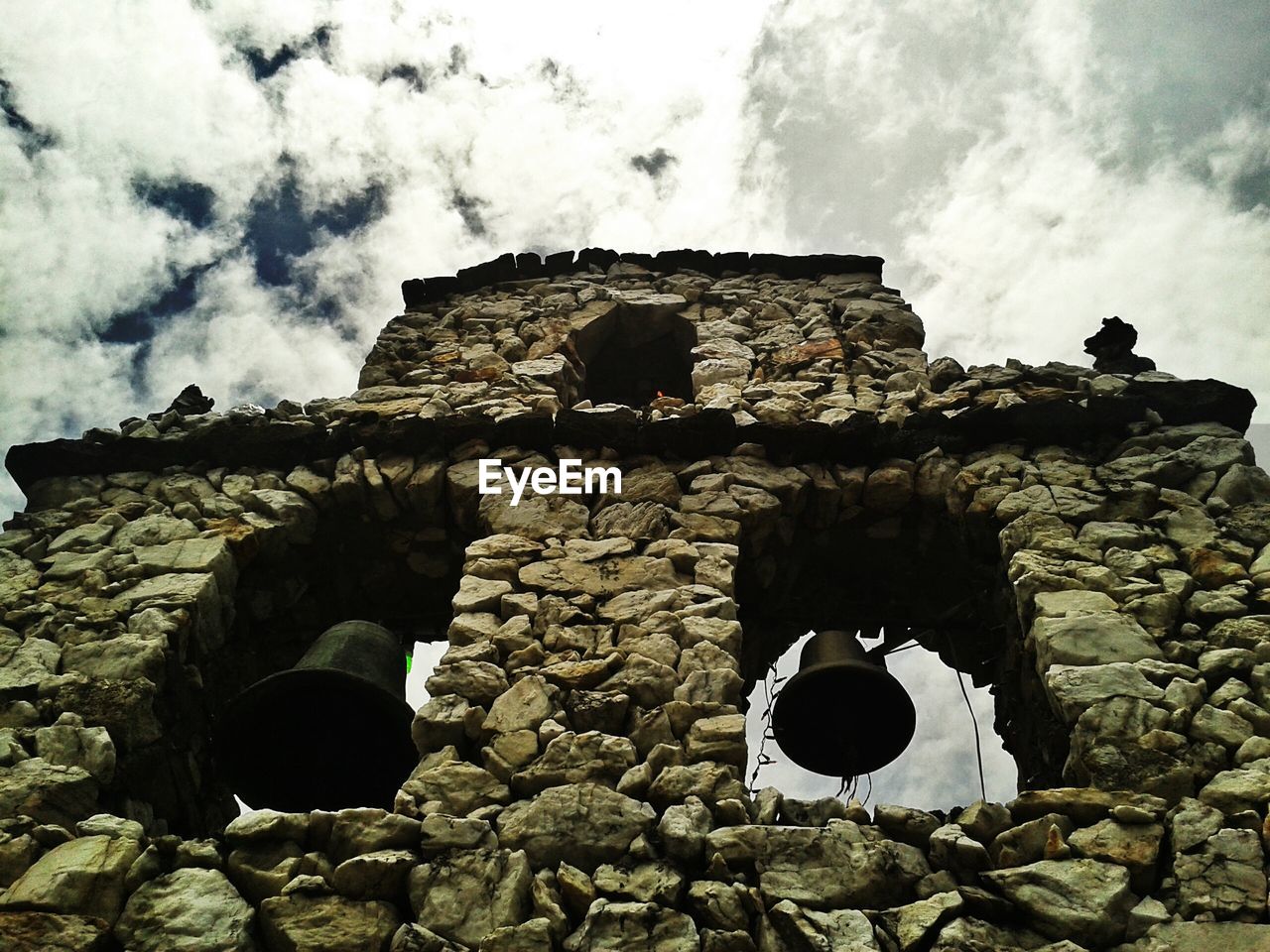 Low angle view of old ruin building against cloudy sky