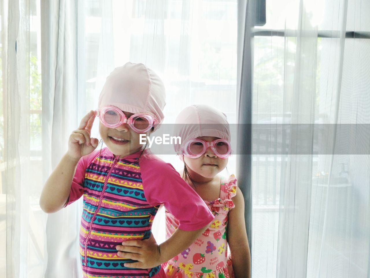 Portrait of cute girls wearing swimming goggles