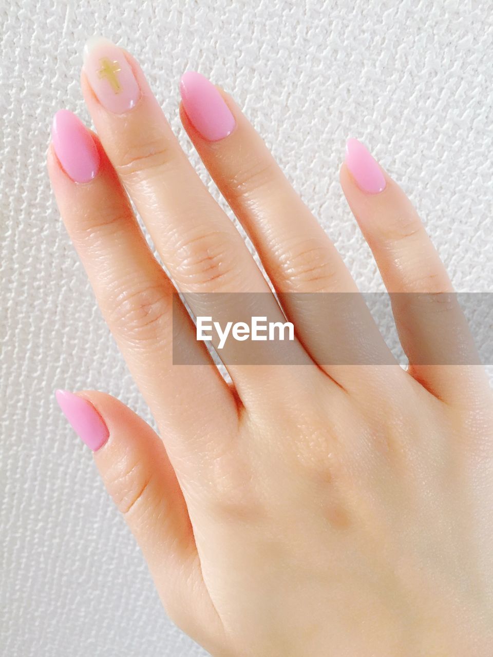 Cropped image of woman showing pink nail polish