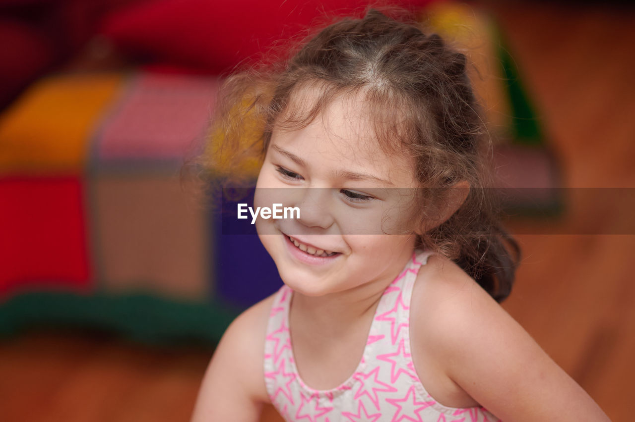 Portrait of a young girl in the livingroom at home making faces and signs of the camera