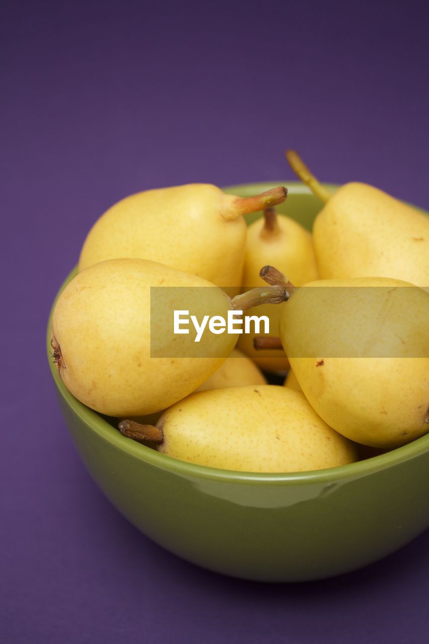 CLOSE-UP OF FRUITS IN PLATE AGAINST GRAY BACKGROUND