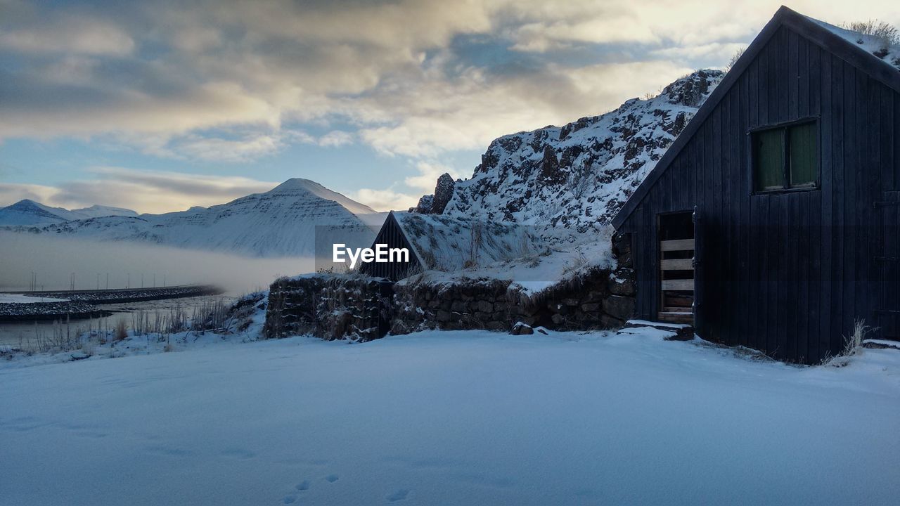 Houses on snowcapped mountains against sky