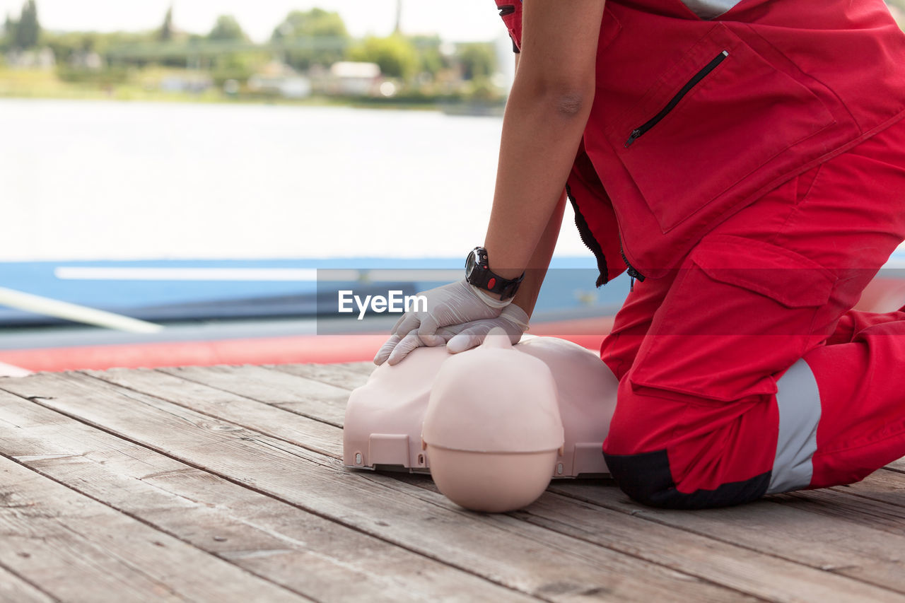 Midsection of man with cpr dummy during training