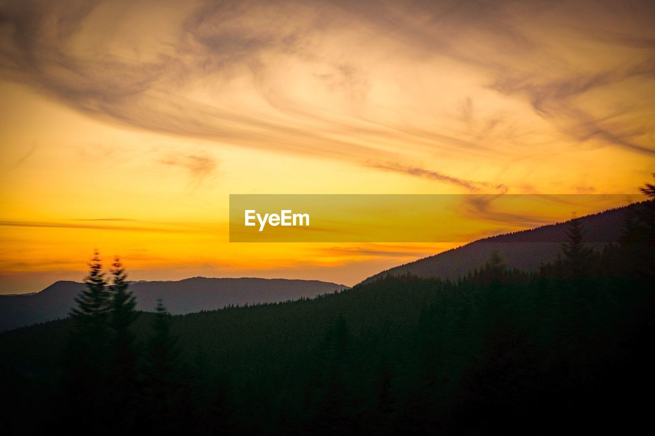 SCENIC VIEW OF MOUNTAINS AGAINST SKY AT SUNSET