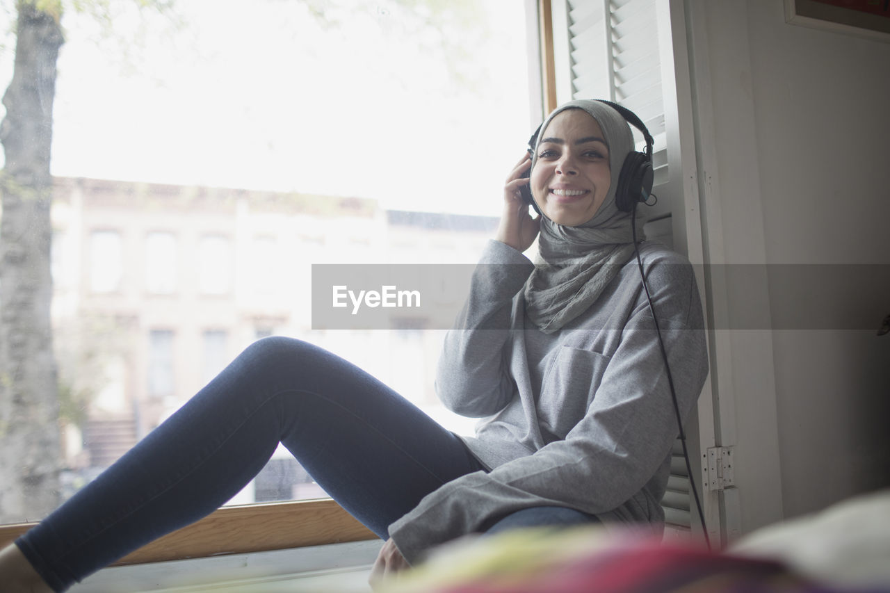 Muslim woman wearing a hijab listening to music