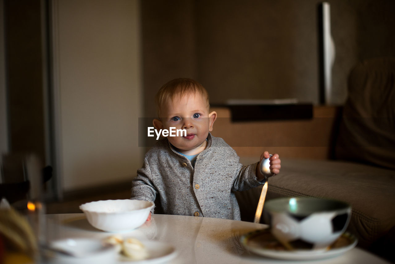 Portrait of cute boy having food at home