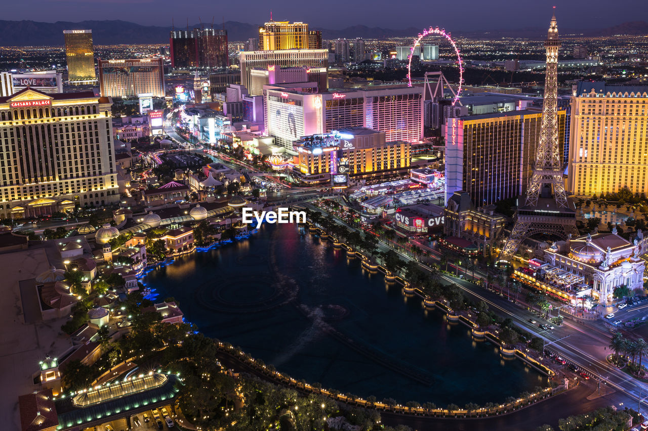 HIGH ANGLE VIEW OF ILLUMINATED BUILDINGS AT NIGHT