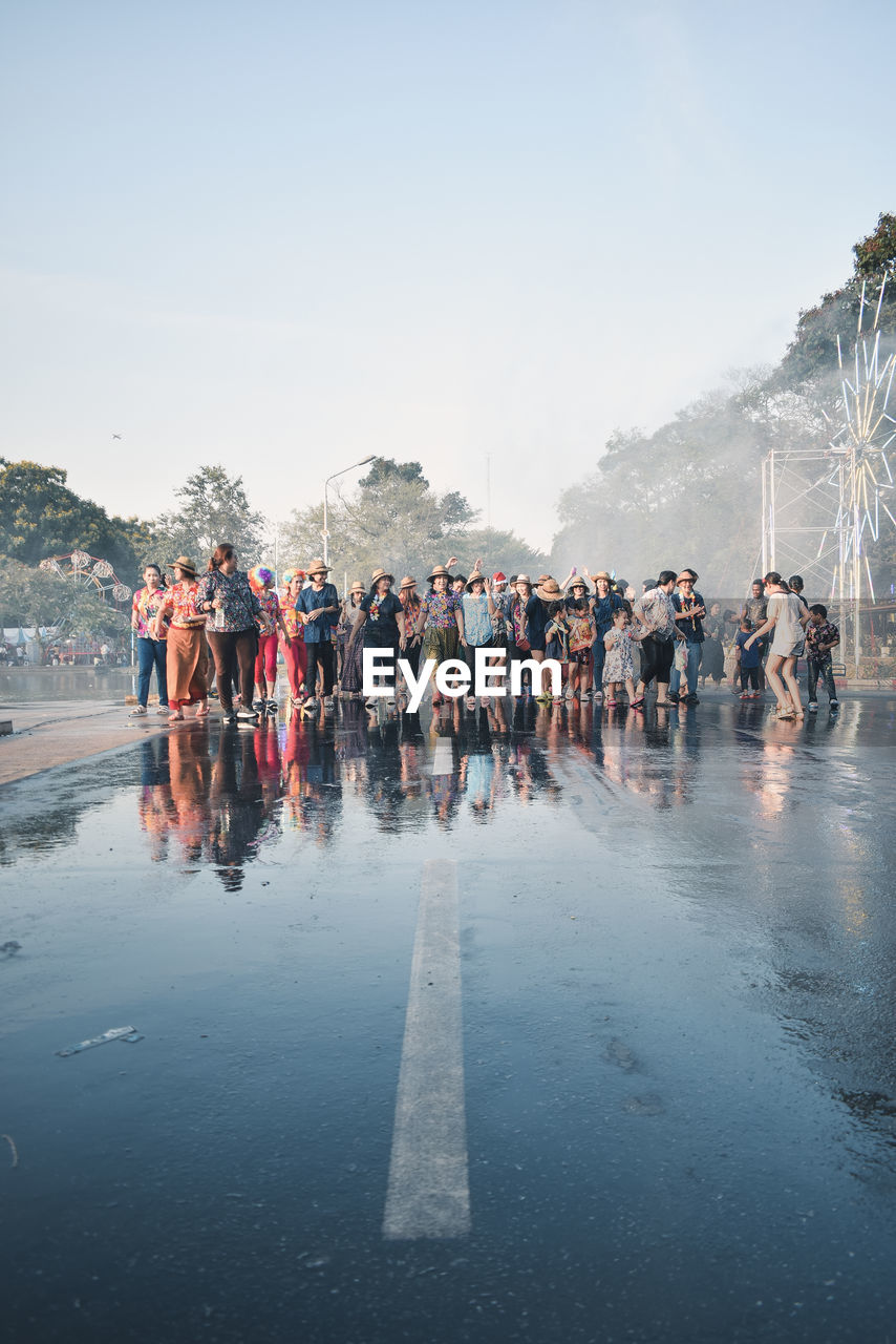 People standing on wet road