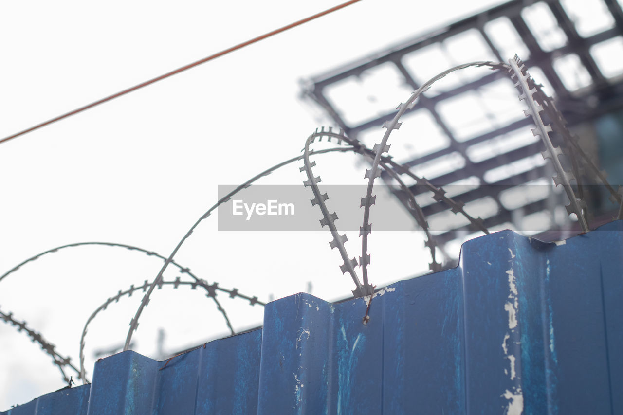 LOW ANGLE VIEW OF BARBED WIRE AGAINST SKY