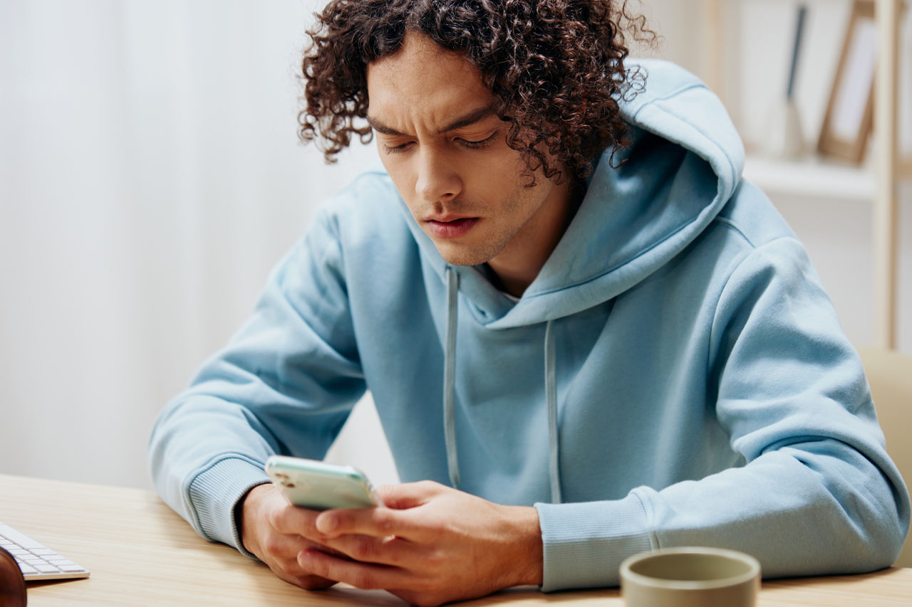 young woman using mobile phone while sitting at home