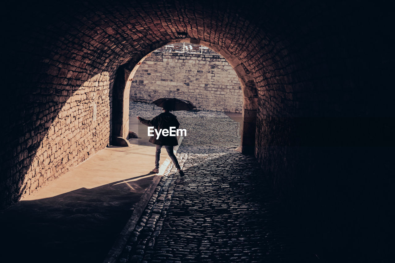 Woman standing in tunnel