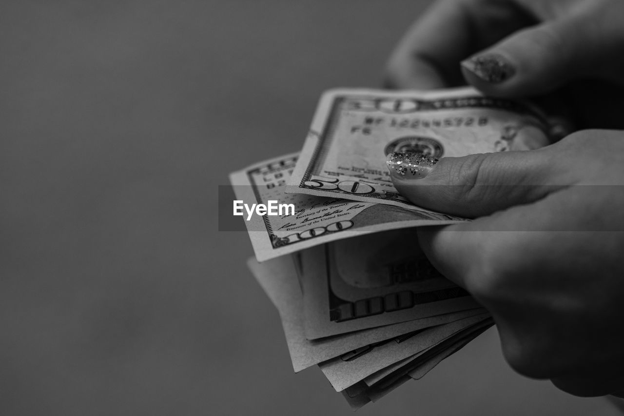 cropped hand of person holding paper currency