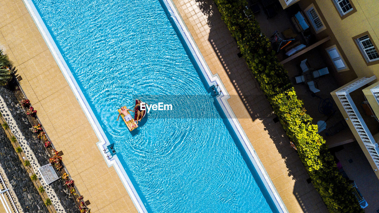 Aerial view of senior couple relaxing in swimming pool