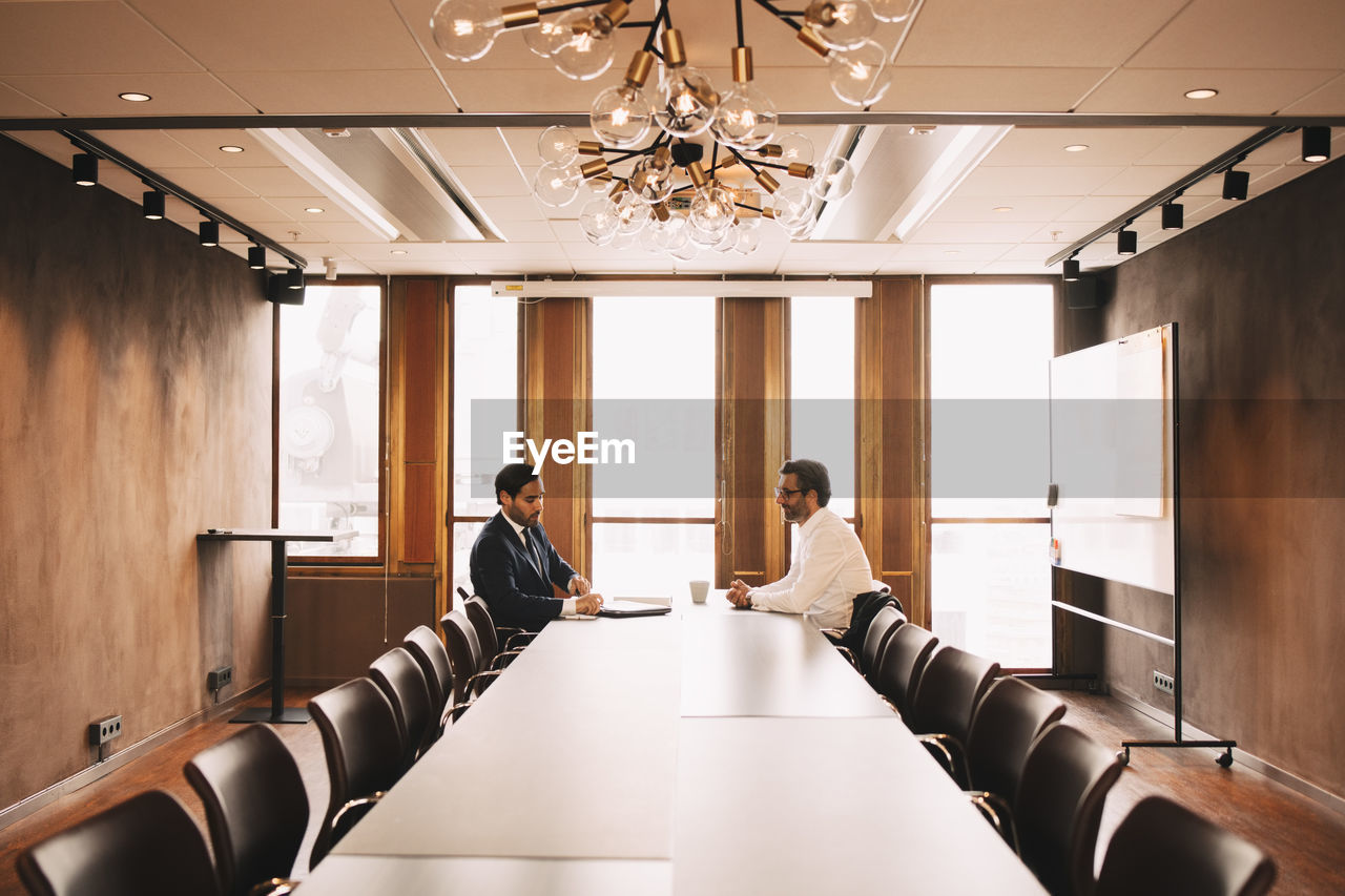 Financial advisor discussing with client in board room at law office