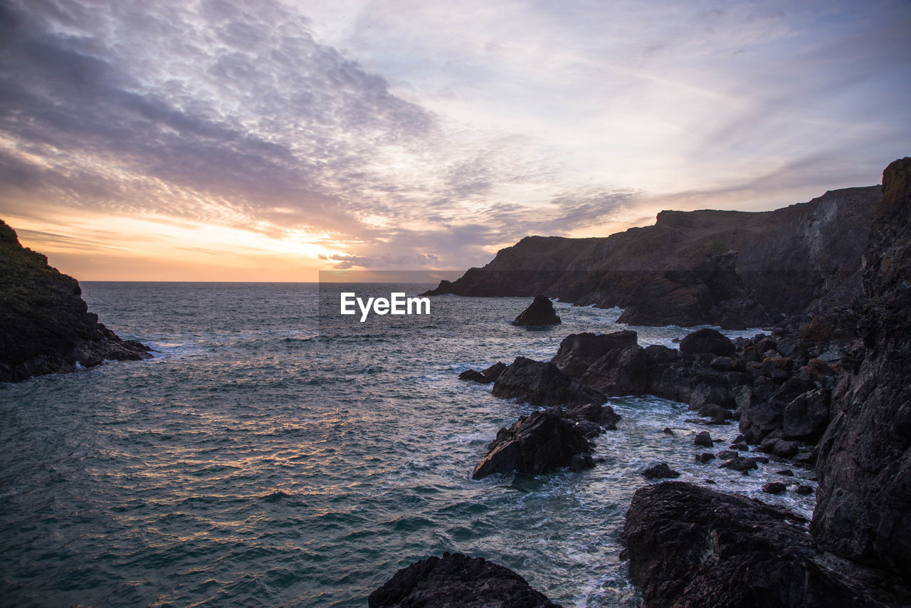 Scenic view of sea against sky during sunset at kynance cove