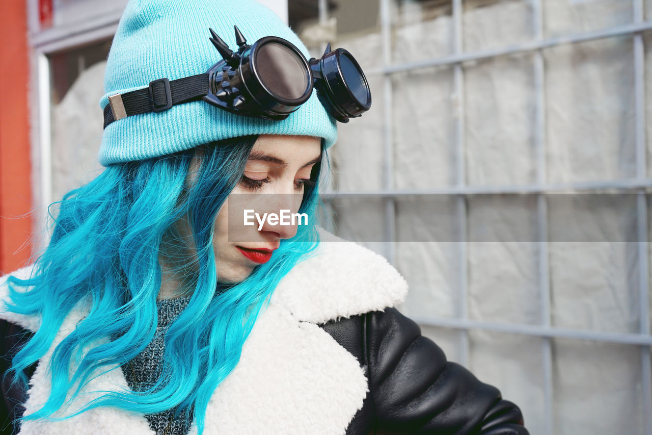 Close-up of fashionable woman with dyed blue hair in city