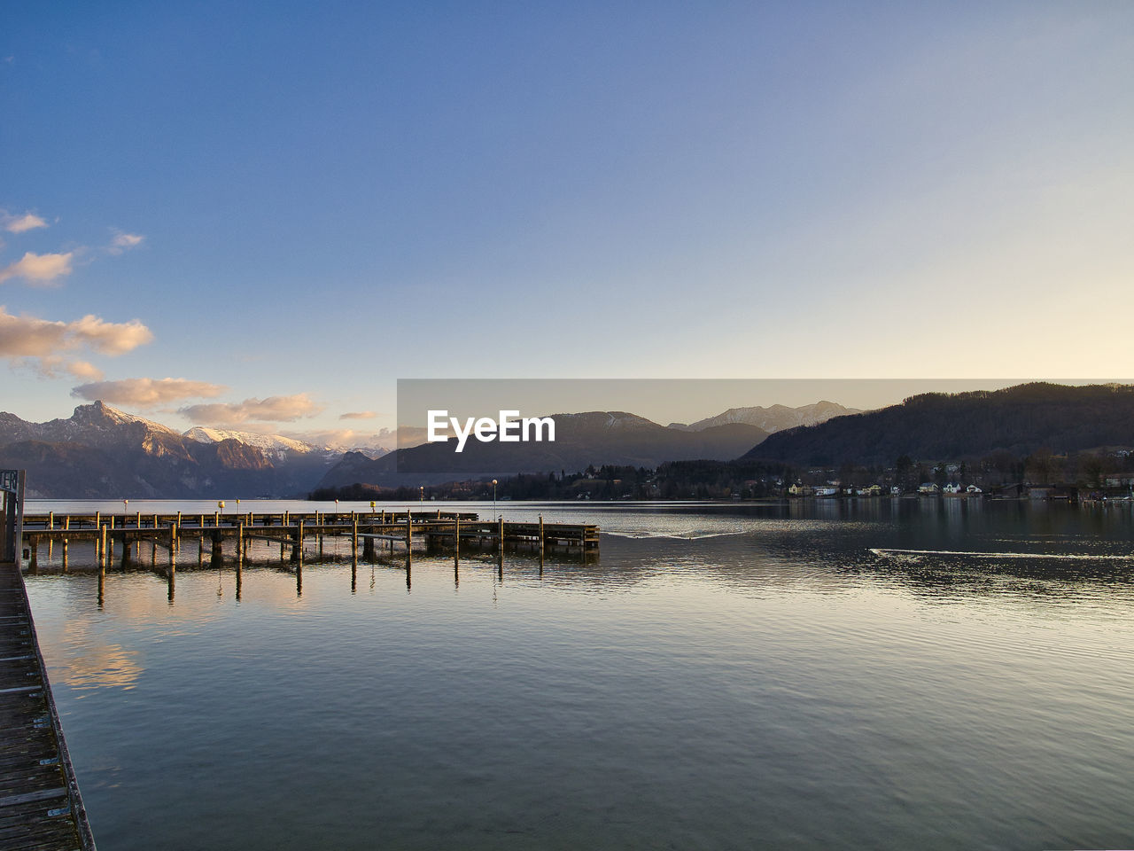 PIER OVER LAKE AGAINST SKY AT SUNSET