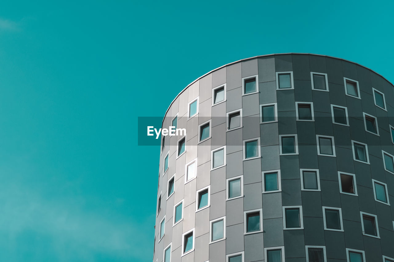 Low angle view of modern building against clear blue sky