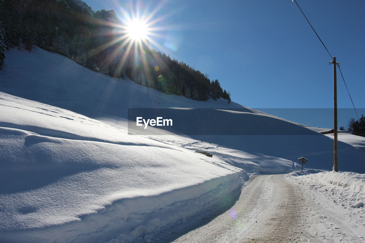 Scenic view of snow covered mountains against sky on sunny day